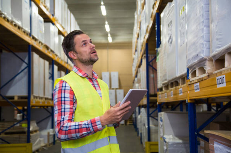 male-warehouse-worker-checking-his-digital-tablet